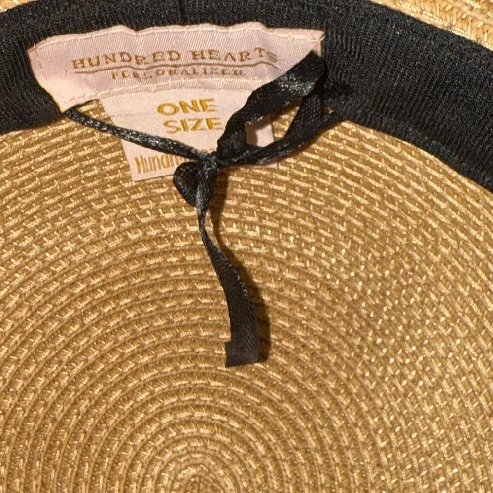 Hundred hearts straw oversized sun hat with black poms around the crown